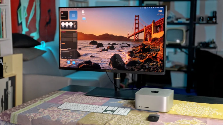 The Mac Studio M5 Ultra is shown with a monitor in an office setup with a dark background