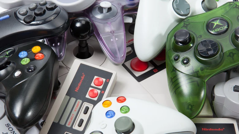 Various older game console controllers against a white background.