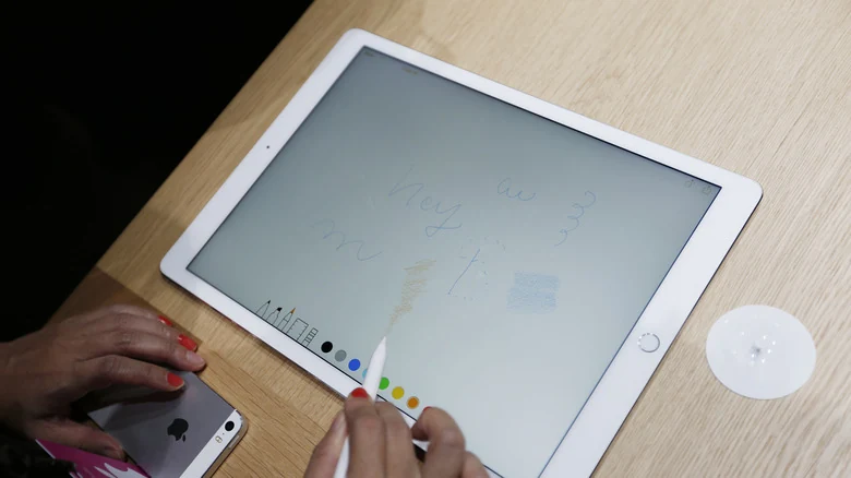 Person drawing on an iPad with an Apple Pencil.