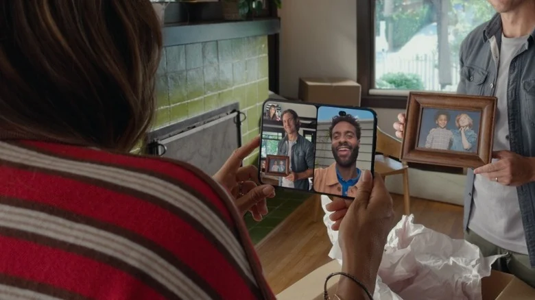 Woman having FaceTime call on iPhone Duo while man holds up picture of kids for camera